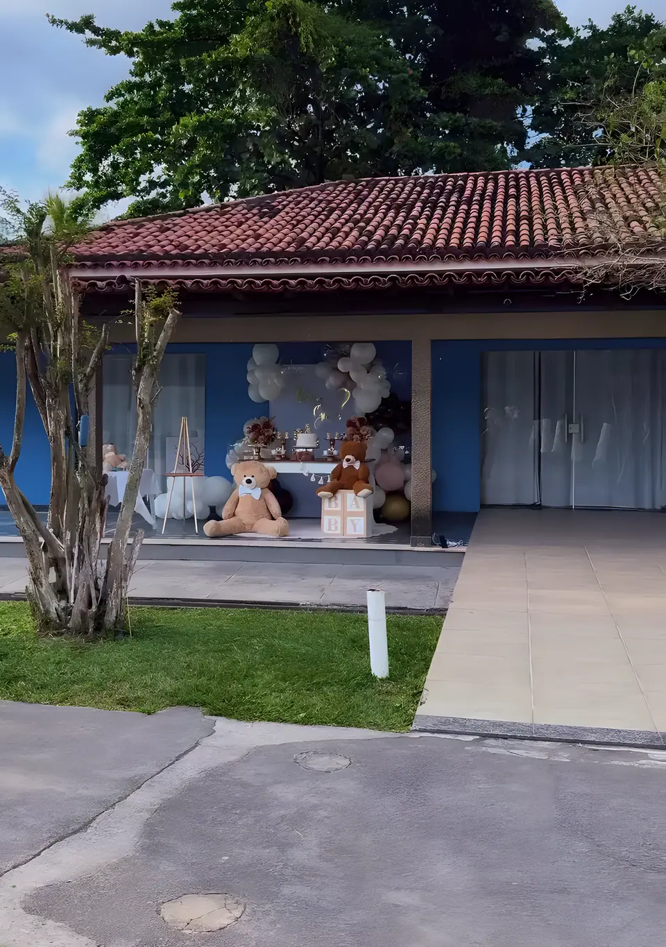 Varanda do Sítio Azul decorada para uma comemoração, com a casa de paredes azuis ao fundo